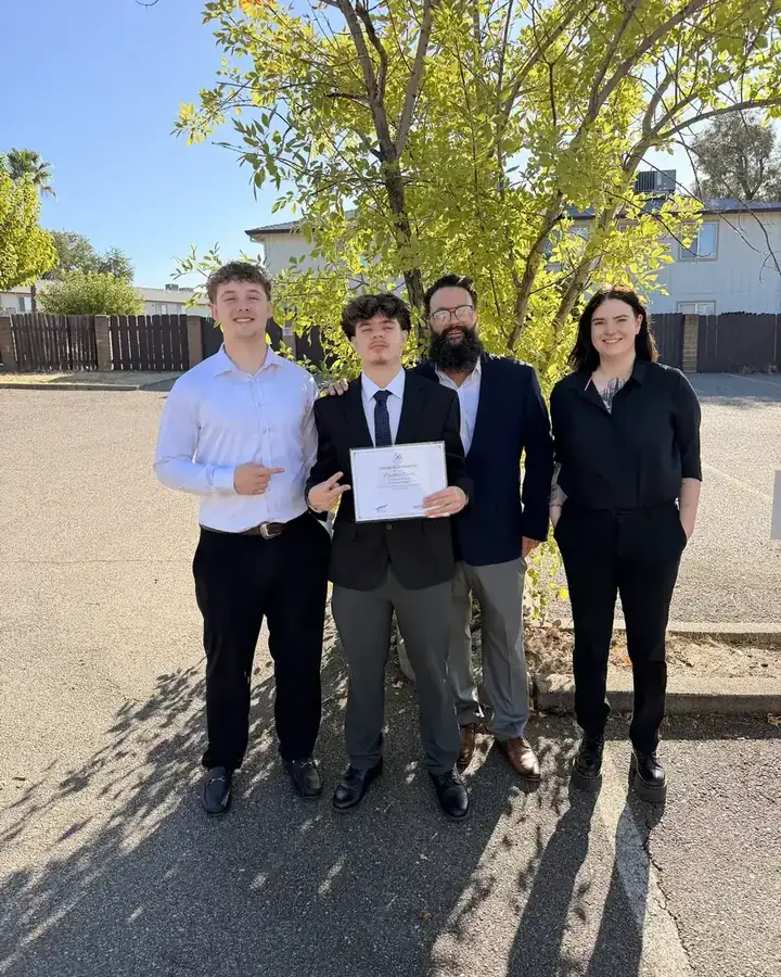A new team leader holding his promotion certificate with JP and the team